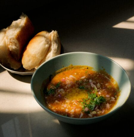 a bowl of soup next to a bowl of bread